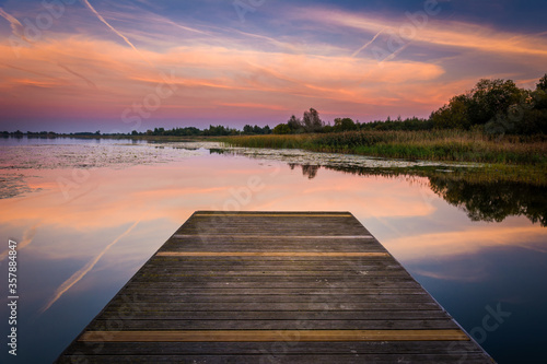 Fototapeta Naklejka Na Ścianę i Meble -  wooden bridge over lake at sunset