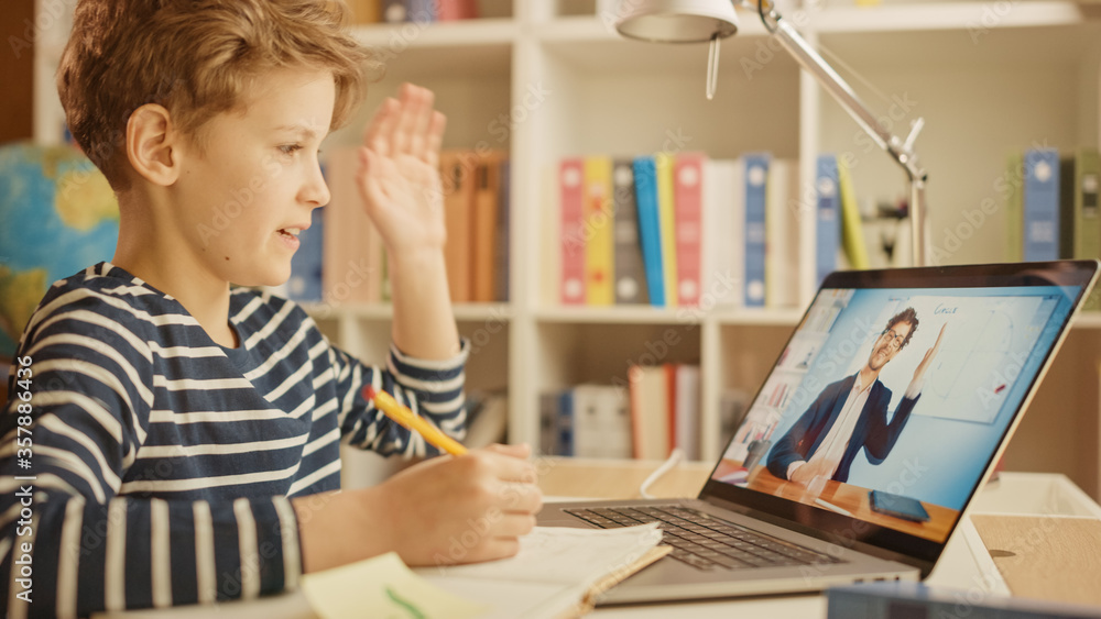 Smart Little Boy Uses Laptop for Video Call with His Teacher. Screen Shows Online Lecture with Teacher Welcomes the Student with Waving Gesture, Boy Answers with Same. E-Education Distance Learning Smart Little Boy Uses Laptop for Video Call with His Teacher. Screen Shows Online Lecture with Teacher Welcomes the Student with Waving Gesture, Boy Answers with Same. E-Education Distance Learning