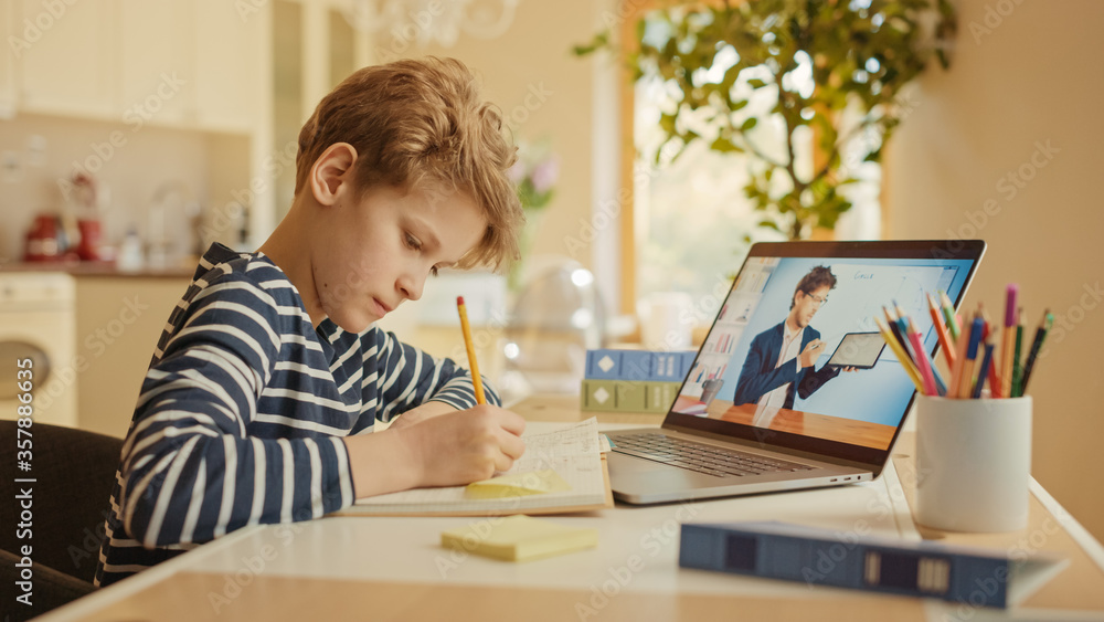 Smart Little Boy Uses Laptop for Video Call with His Teacher. Screen Shows Online Lecture with Teacher Explaining Subject from a Classroom. E-Education Distance Learning, Homeschooling. Smart Little Boy Uses Laptop for Video Call with His Teacher. Screen Shows Online Lecture with Teacher Explaining Subject from a Classroom. E-Education Distance Learning, Homeschooling.