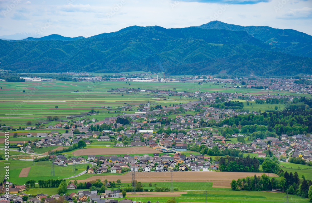 Slovenian countryside in spring with charming little village and Julian Alps in the background