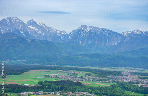 Fototapeta Naklejka Na Ścianę i Meble -  Slovenian countryside in spring with charming little village and Julian Alps in the background