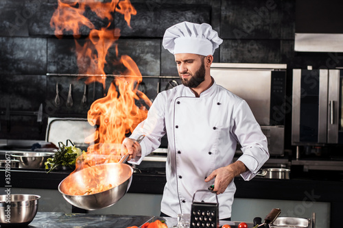 Принти на полотні Chef cook food with fire at kitchen restaurant