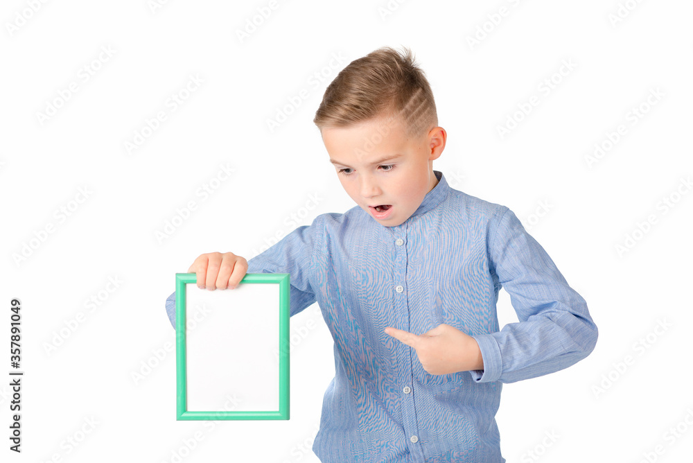 Surprised young caucasian schoolboy in shirt posing on white studio isolated background. lifestyle concept. Mock up copy space. Poke at white empty blank billboard with place for text or image. Surprised young caucasian schoolboy in shirt posing on white studio isolated background. lifestyle concept. Mock up copy space. Poke at white empty blank billboard with place for text or image.