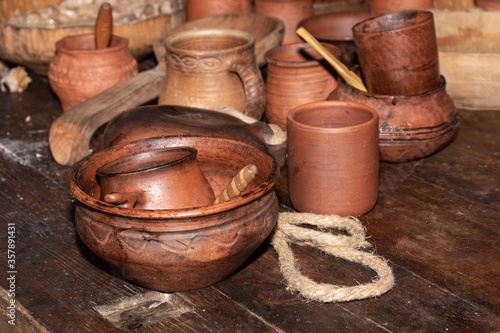 Ceramic bowls and cups on a wooden table. Historical folkware.