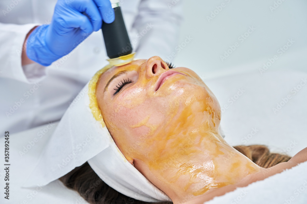 Beautiful young woman getting face treatment at beauty salon. Beautiful young woman getting face treatment at beauty salon.