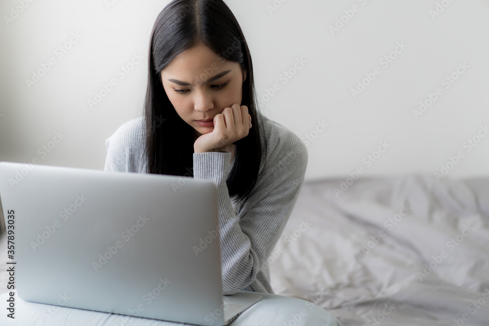 Young beautiful woman works from home with laptop computer at the the bedroom, living room.Communication and video conference concept Young beautiful woman works from home with laptop computer at the the bedroom, living room.Communication and video conference concept