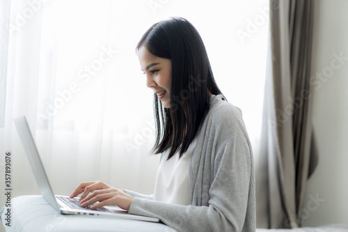 Young beautiful woman works from home with laptop computer at the the bedroom, living room.Communication and video conference concept