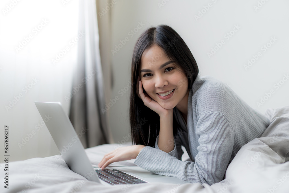 Young beautiful woman works from home with laptop computer at the the bedroom, living room.Communication and video conference concept Young beautiful woman works from home with laptop computer at the the bedroom, living room.Communication and video conference concept