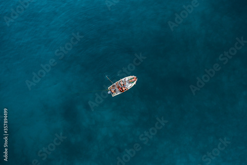 Friends chilling on a small boat, top down view