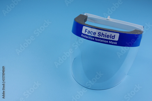 Face shield to protect against viruses on a blue background.
