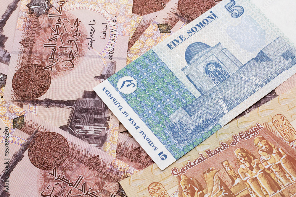 A close up image of a five somoni bank note from Tajikistan in macro with a background of Egyptian one pound bank notes A close up image of a five somoni bank note from Tajikistan in macro with a background of Egyptian one pound bank notes