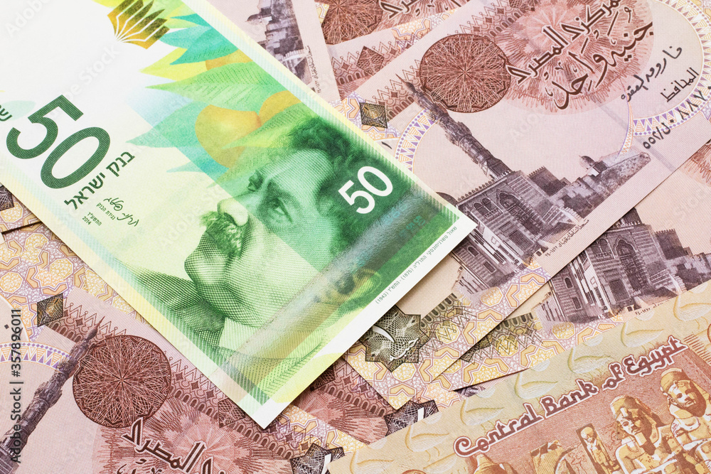 A close up image of a fifty shekel bank note from Israel on a background of Egyptian one pound bank notes in macro