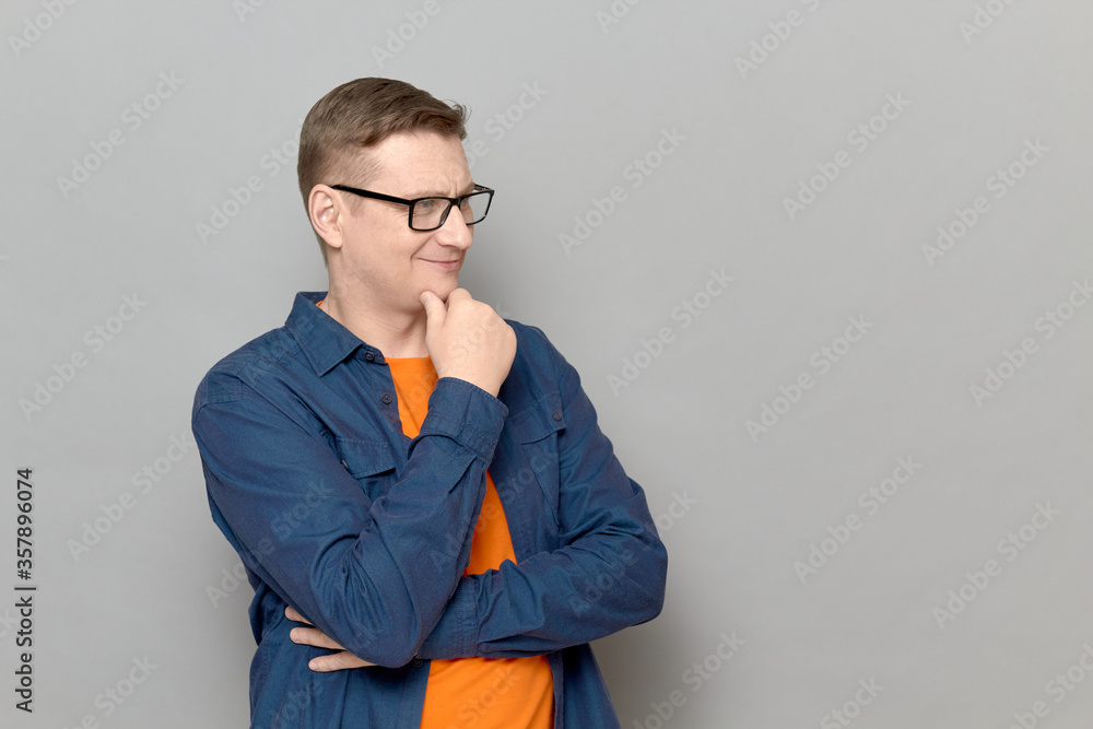 Portrait of thoughtful man touching chin with hand and smiling Portrait of thoughtful man touching chin with hand and smiling