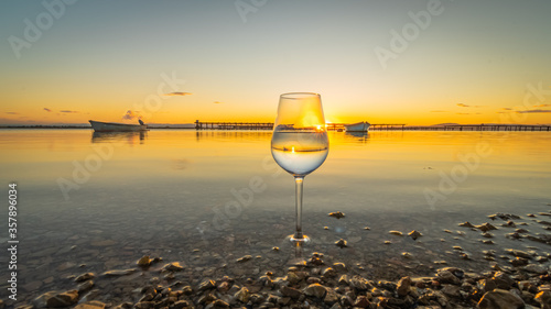 Verre    vin avec reflets d un coucher de soleil sur la mer.