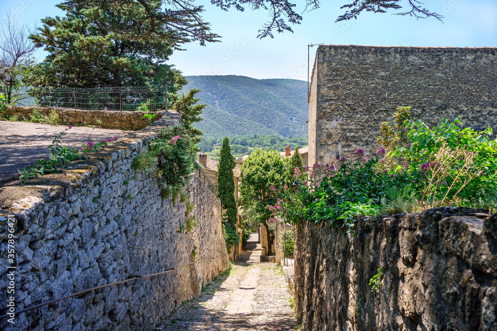 Rue pavée du village Bonnieux en Provence, France. Massif du Luberon en arriéré plan.