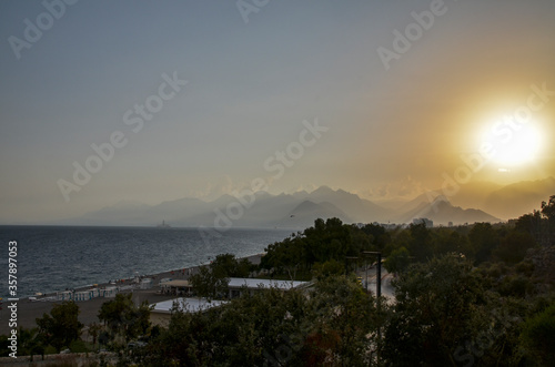 Panoramic view of Konyaalti beach and Mediterranean sea at mountains background during sunset in Antalya, Turkey