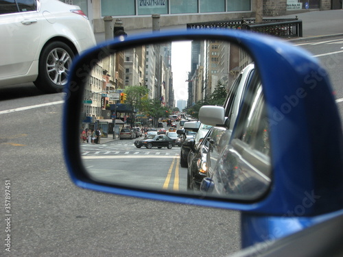 City street reflected in a car mirror
