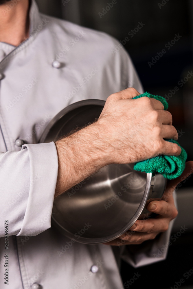Chef hands dry bowl with duster. Closeup hands wipe bowl with green duster.