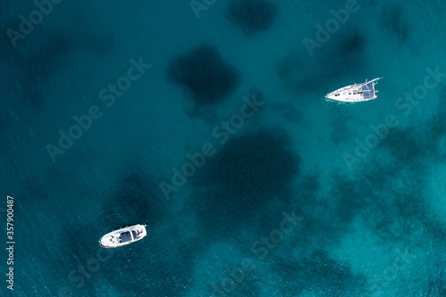 Top view of two boats floating above deep blue texture
