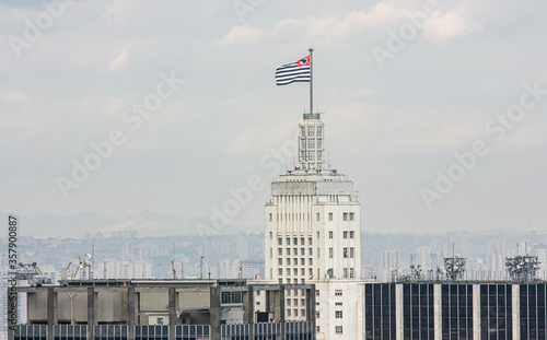 Topo do edifício Altino Arantes, com a bandeira do Estado de São Paulo ao vento e a cidade no horizonte. photo
