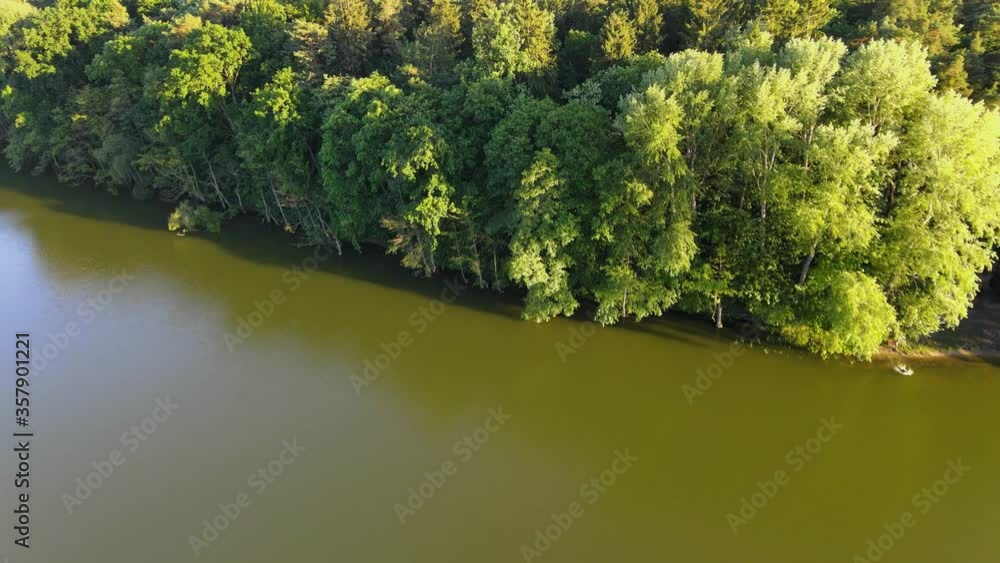 Lot wysoko nad jeziorem w środku lasu, widok na jezioro, wodę i gęsty las Lot wysoko nad jeziorem w środku lasu, widok na jezioro, wodę i gęsty las