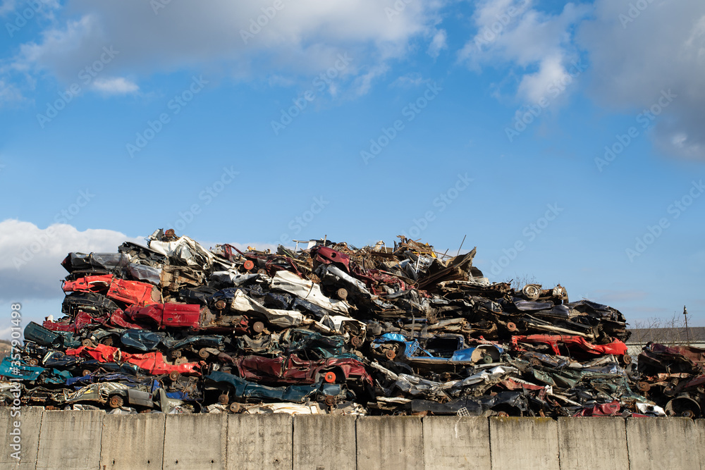 Obraz premium Old damaged wrecked cars on the junkyard waiting for recycling