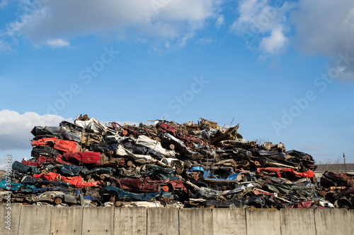Old damaged wrecked cars on the junkyard waiting for recycling photo