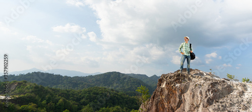 Tourist with travel backpack on the top of mountain. Travel concept. Panoramic and banner edition.