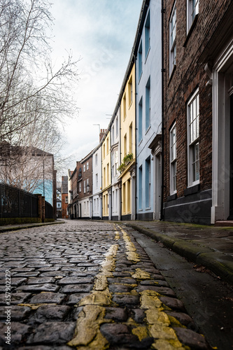 Colourful victorian houses facing a cobbled street. Double yellow lines outside the houses in Hull, Yorkshire