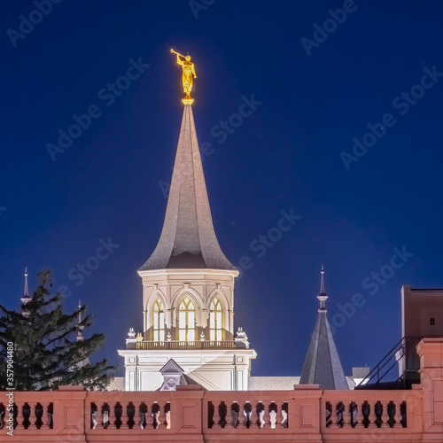 Square Provo City Center Temple with statue of angel and spire against blue evening sky