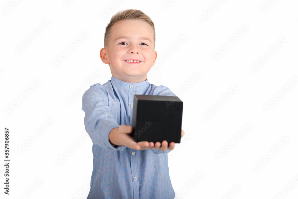 Smiling caucasian blond boy in blue shirt holds black box.the box is in front.Isolate white background.Close up.