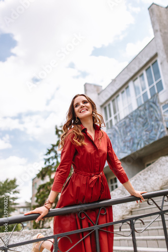 A girl in a red dress, standing on the stairs