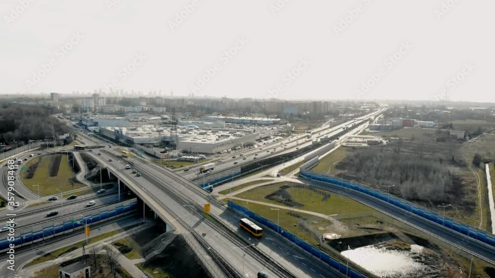 Drone view of traffic on contemporary asphalt highway with junction near modern city Drone view of traffic on contemporary asphalt highway with junction near modern city