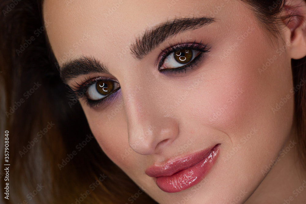 Close-up portrait of a beauty woman with straight hair and perfectly clean skin. Evening makeup, styling and elegant decoration on the ears - earrings. Skin care in the spa salon or cosmetology smile Close-up portrait of a beauty woman with straight hair and perfectly clean skin. Evening makeup, styling and elegant decoration on the ears - earrings. Skin care in the spa salon or cosmetology smile