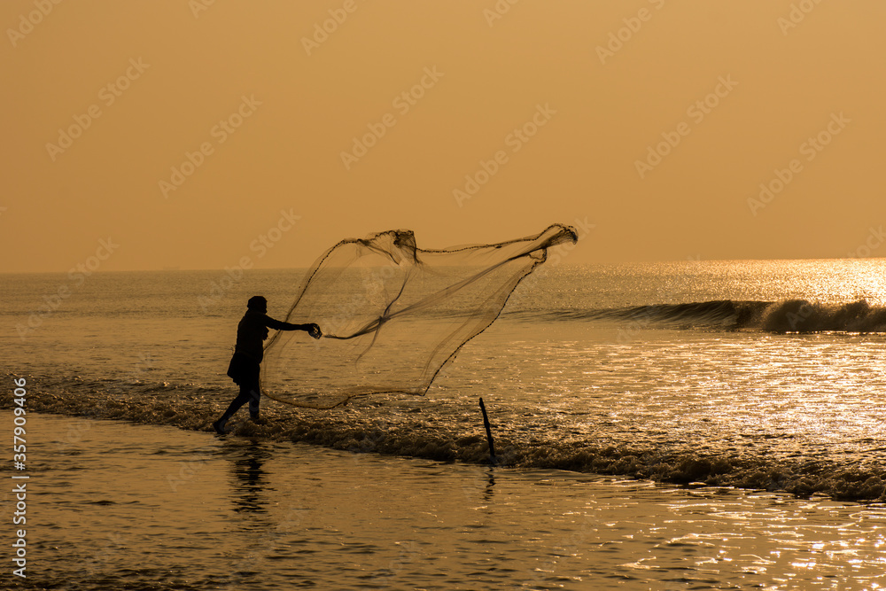 A fisher man throwing his fishing net