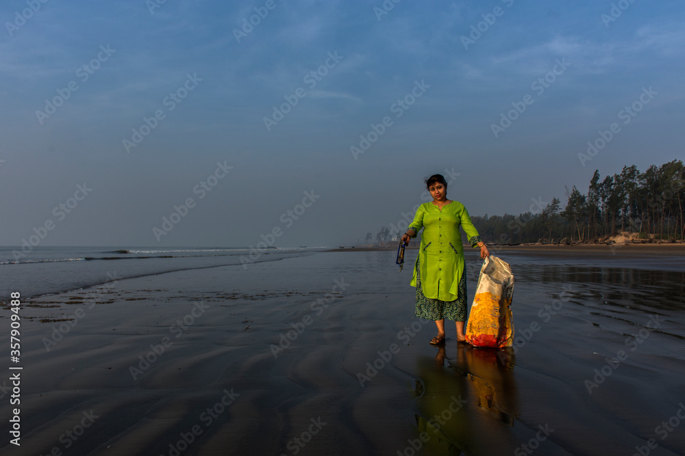 A lady cleaning sea beach