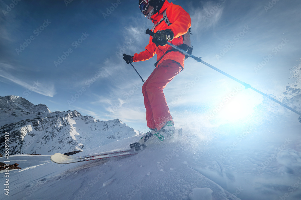 close up Skier rides on a snowy slope on a sunny day at sunset against the backdrop of the mountains. The concept of winter skiing