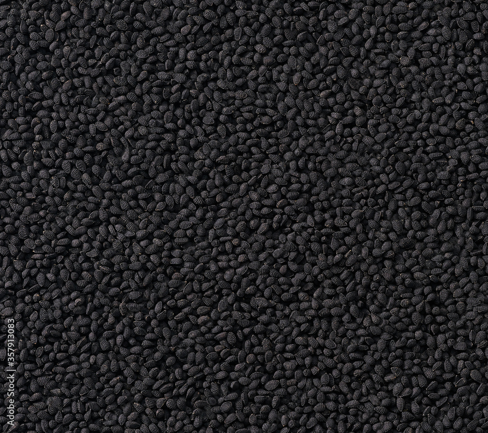 Fototapeta premium black caraway seeds as texture background, top view.