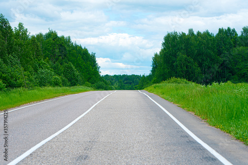 Empty asphalt road empty road between green trees in Russia, summer landscape