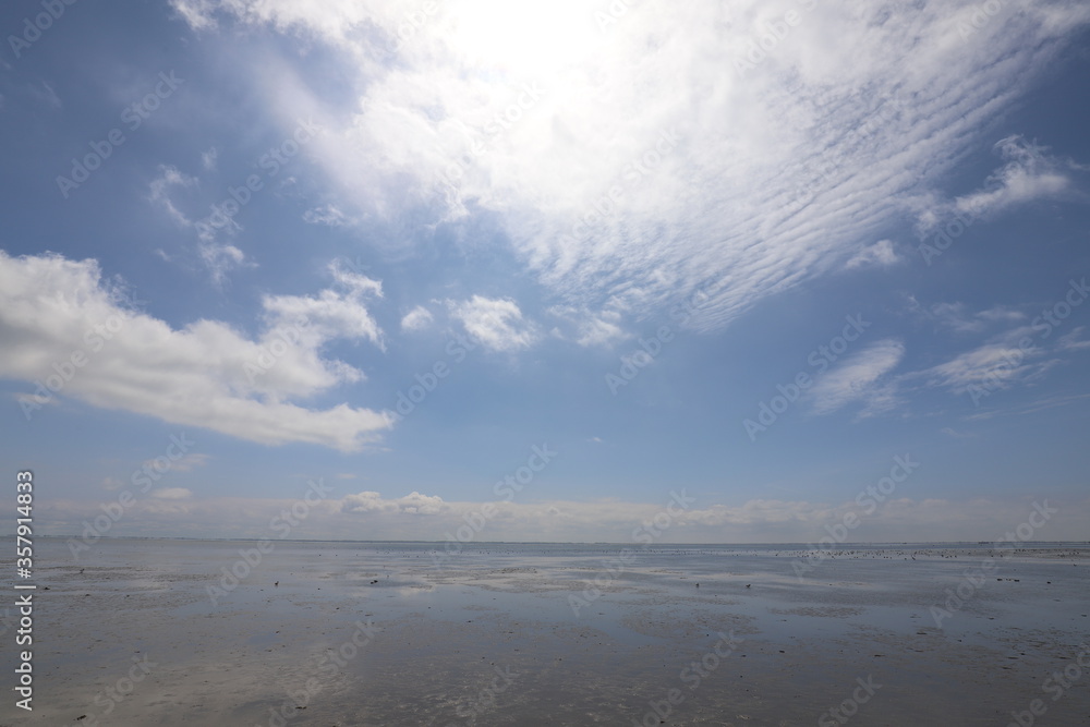 Beautiful panoramic view over the Sea at very low tide with a blue sky. Photo was taken on a sunny May day with a beautiful blue lunch with white clouds. Beautiful panoramic view over the Sea at very low tide with a blue sky. Photo was taken on a sunny May day with a beautiful blue lunch with white clouds.