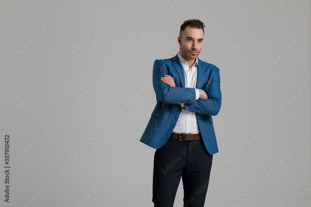 young smartcasual guy looking to side and crossing arms young smartcasual guy looking to side and crossing arms