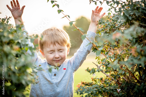 Boy with arms out closing eyes photo