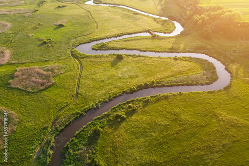 Aerial view landscape of winding river in green field.