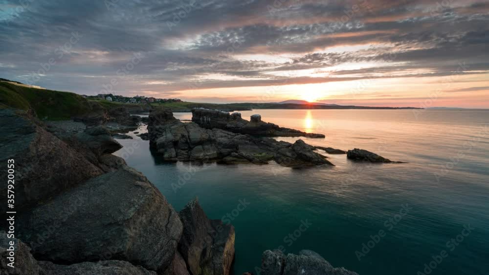 Time lapse with colorful sunset sky at rocky coastline and calm summer sea, the Black Sea coast, Bulgaria Time lapse with colorful sunset sky at rocky coastline and calm summer sea, the Black Sea coast, Bulgaria