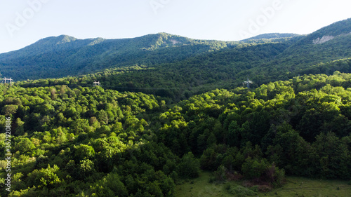 Beautiful landscape view of the valley. Trees  river and mountain range in the background. Clear sky  Sunny spring day. Drone shot A bird s-eye view of the landscape. drone photography