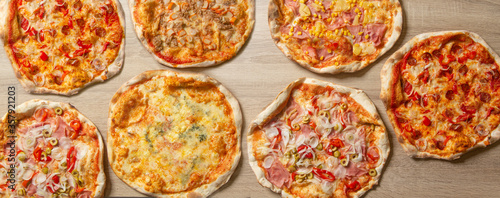 Background of assorted pizzas on table seen from above. Pizza banner.