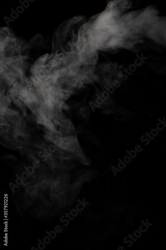 A stream of white smoke on a black background mixes randomly creating bizarre swirl patterns