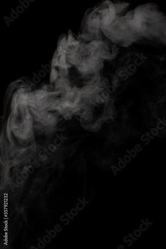 A stream of white smoke on a black background mixes randomly creating bizarre swirl patterns