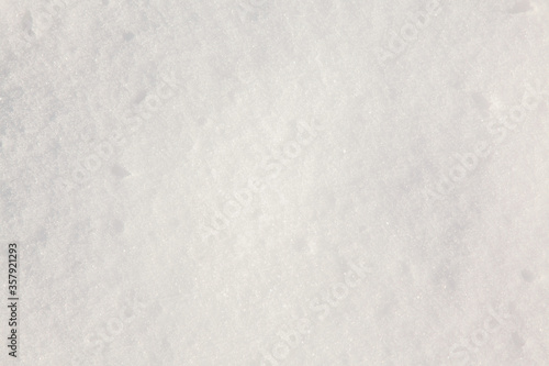 White snow on the ground on a clear sunny day. Snow texture