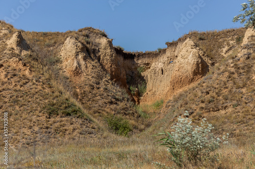 Mountain landslide in an environmentally hazardous area. Large cracks in earth  descent of large layers of earth blocking road. Mortal danger of dam at foot of landslide slopes of mountain